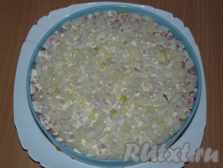 Поверх ветчины выложить слой лука и утрамбовать.