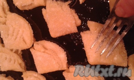 Опять - в сахар. Выложить на противень, смазанный подсолнечным маслом, сахарной стороной вверх. Надавить вилкой, чтобы сделать лапки.