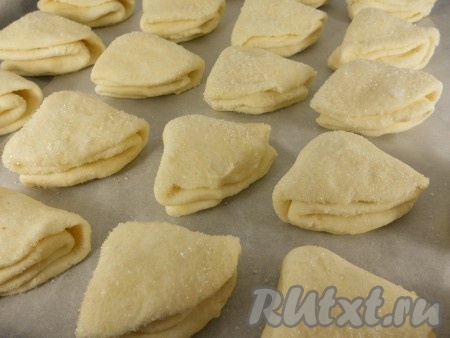 Противень застелить пергаментом. Выложить все заготовки&nbsp;творожного печенья "Поцелуйчики" на противень сахарной стороной вверх, оставляя между печенюшками немного свободного места.