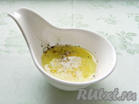 Для приготовления заправки для салата смешать масло, лимонный сок, выдавить чеснок и добавить свежесмолотый черный перец. Все перемешать.
