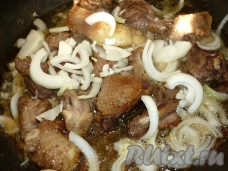 Добавляем лук к приготовленному утиному мясу и обжариваем, помешивая, до золотистого цвета.
