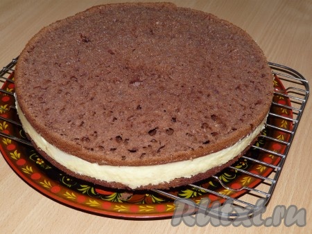 Сверху выложить вторую часть коржа. Слегка прижать коржом крем. Затянуть верх формы пищевой плёнкой и поставить торт в холодильник на ночь. Затем аккуратно снять бортики формы.