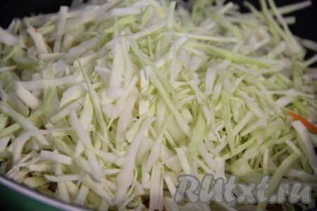 Капусту тонко нашинковать, выложить к овощам, хорошо перемешать. Тушить под крышкой 5-7 минут, периодически помешивать.