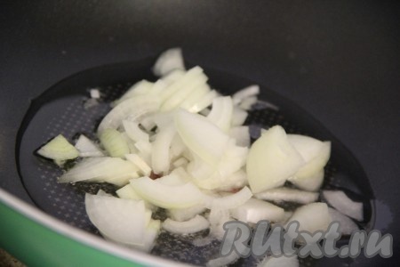 В сотейник или сковороду вок налить растительное масло и поставить на огонь. Лук почистить и нарезать полукольцами. Выложить лук в сковороду и слегка обжарить.
