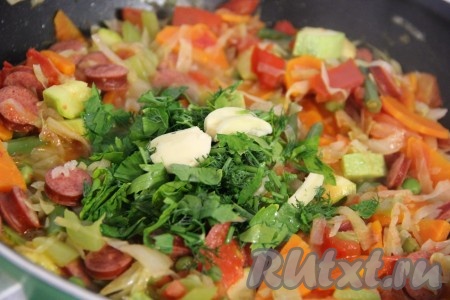 Зелень вымыть, мелко нарезать. Чеснок почистить, раздавить ножом. Добавить зелень и чеснок к овощам, всё хорошо перемешать. Закрыть овощное рагу с колбасой крышкой и снять с огня. Дать настояться минут 15.
