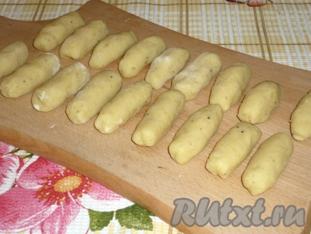 Полученные кусочки теста прокатать рукой по доске с мукой, формируя таким образом палюшки.
