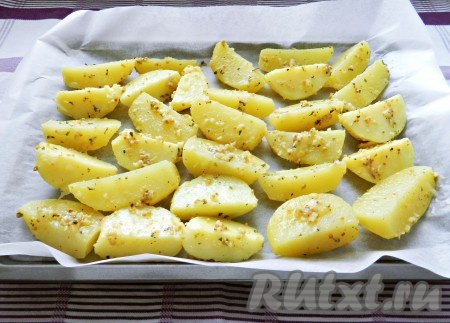 Противень застелить пергаментом, выложить картофель в один слой.
