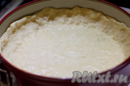 Распределите тесто руками по дну формы, создавая бортики.
