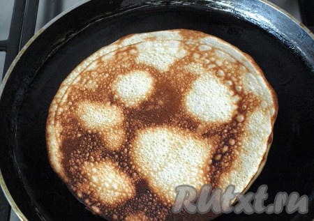 Затем манный дрожжевой блин перевернуть и обжарить с другой стороны до румяности.
