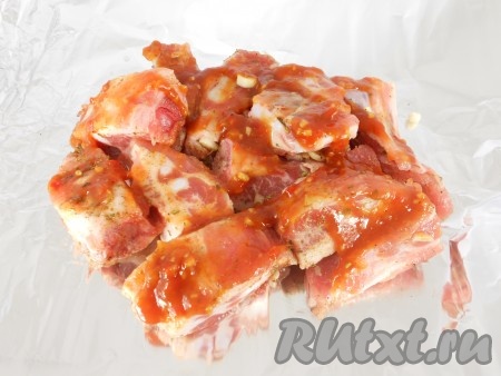 Добавить аджику, хорошенько перемешать свиные рёбрышки.