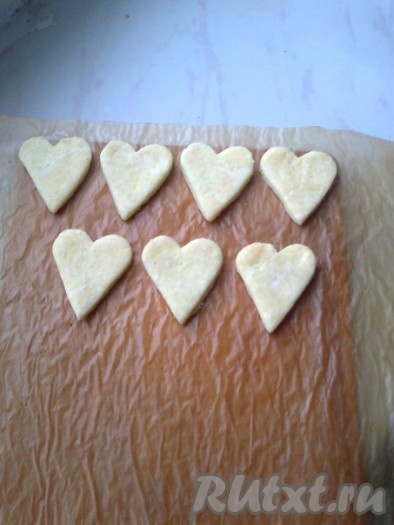 Раскатать тесто толщиной 0,3-0,5 см. Вырезать выемкой из теста заготовки&nbsp; в виде сердечек. Сложить на пергаментную бумагу для выпечки.
