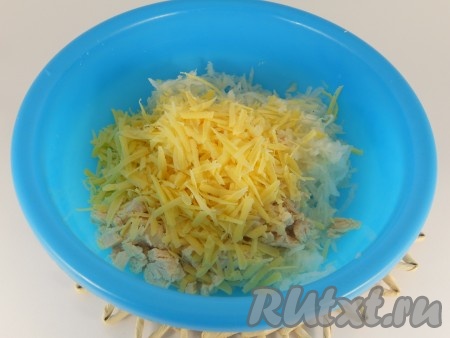 В салат с мясом курицы и дайконом выложить натёртый на крупной тёрке сыр.