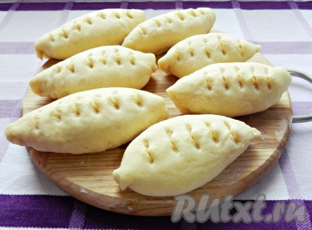 Выложить пирожок швом вниз. На поверхности пирога сделать неглубокие надрезы ножницами (можно придать пирожкам любую форму по своему желанию). Постепенно сформировать все 16 пирожков.