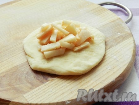 Тесто разделить на порционные кусочки (я разделила на 16 кусочков). Кусочек теста на припылённой мукой поверхности размять руками в лепёшку, на середину выложить часть яблочной начинки и слепить пирожок.