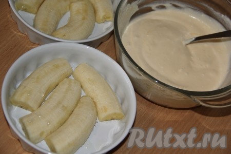 Творог лучше всего брать мягкий, жирностью не менее 5%. В глубокой миске соединить творог, яйцо, сахар и сметану, тщательно перемешать столовой ложкой (до однородности). Консистенция творожной массы должна получиться воздушной и нежной. Бананы почистить, разрезать в длину на 2 половины, затем каждую половинку разрезать поперёк на 2 части (при желании можно нарезать банан и кружочками). Выложить нарезанные бананы срезом вниз в один слой на дно двух формочек (или одной формы). Я использовала 2 керамические формочки для запекания.