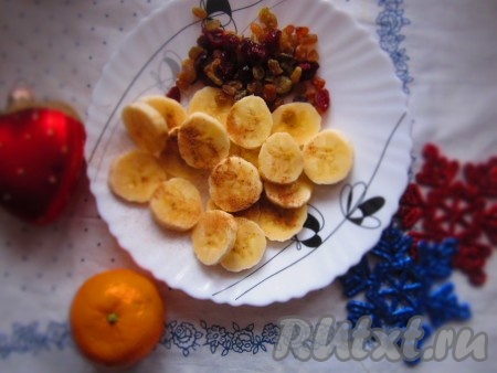 Пока остывает крем, порезанный кружками&nbsp;банан посыпать корицей, изюм и клюкву замочить в тёплой воде.
