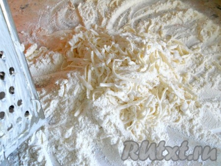 Для приготовления этого быстрого слоеного бездрожжевого теста все продукты должны быть очень холодными. Маргарин (масло) желательно предварительно подержать в морозилке пару часов. 

Муку просеять, часть насыпать на поверхность стола. Маргарин на крупной терке натирать частями в муку, каждую из натёртых частей маргарина сразу же смешивать с просеянной мукой. Делать это нужно легко, не сжимая маргарин.