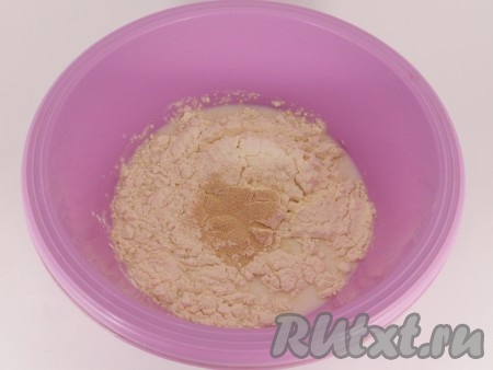 Половину муки просеять в глубокую миску, всыпать дрожжи и 1 столовую ложку сахара.&nbsp;
