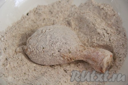 Куриные ножки достать из маринада, удалить лишнюю жидкость и кусочки лука. Хорошо обвалять в панировке куриную ножку со всех сторон. Обваливать в панировке нужно столько ножек, сколько одновременно поместится у вас во фритюр.