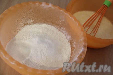 Муку просеять и соединить с разрыхлителем. Влить жидкую смесь в муку и хорошо перемешать до однородного состояния.