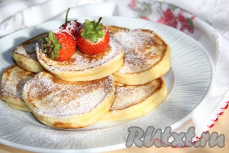 Вкусные, пышные оладьи на кефире, приготовленные по этому простому рецепту, подать с сахарной пудрой и свежими фруктами.