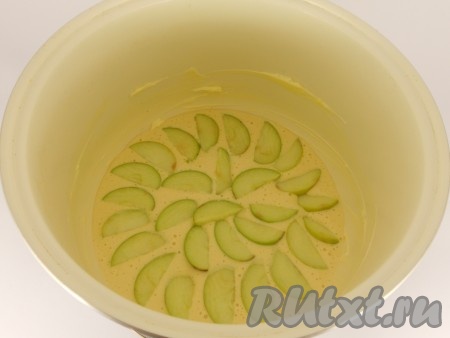 Чашу мультиварки хорошо смазать сливочным маслом, вылить половину теста. Яблоки очистить от сердцевины и нарезать дольками. Выложить половину яблок сверху на тесто. Вылить оставшееся тесто и также сверху выложить оставшиеся яблоки.