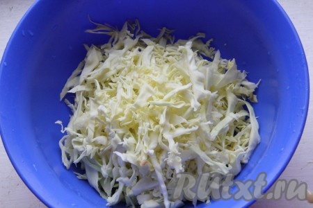 Капусту нарезать на тонкие полоски, переложить в миску, присолить и помять слегка руками.