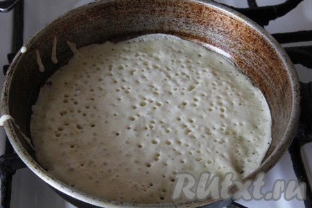 Разогреть сковороду, смазать растительным маслом. Выпекать дрожжевые блины с двух сторон до золотистого цвета на среднем огне. Блины получаются с дырочками, пышными, толщиной 3-4 миллиметра, если есть необходимость, делайте их толще.