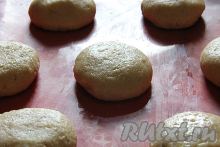 Тесто разделить на маленькие колобки. Такие пряники можно сделать и с начинкой, для этого колобок нужно раскатать и выложить на получившуюся лепёшку немного начинки (например, густое варенье, джем или шоколадную пасту), собрать края лепёшки над начинкой, формируя колобок. Можно делать пряники и без начинки - тут уже решайте сами. Получившиеся колобки выложить на расстоянии друг от друга на противень, застеленный силиконовым ковриком (или бумагой для выпечки). Руками прижать колобки, сформировав округлые пряники.