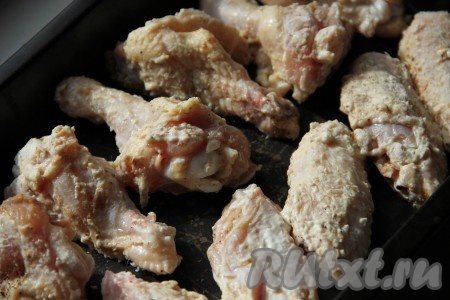 Выложить куриные крылышки в форму для запекания, заранее застеленную ковриком для выпечки (или пергаментной бумагой).