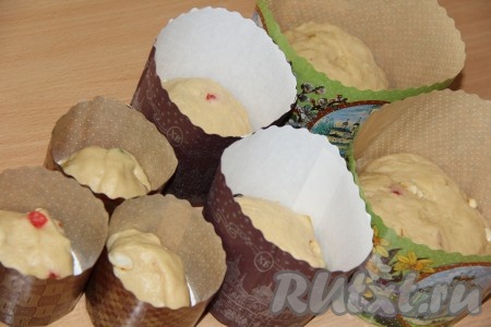 Тесто разложить по формам, заполняя их на 1/3 объёма. Накрыть формы с тестом полотенцем и оставить в тёплом, без сквозняков, месте на 3-4 часа. Я использовала бумажные формы для куличей, можно выпекать куличи в жестяных или силиконовых формах, предварительно смазав их растительным маслом.