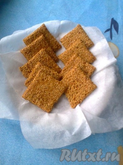 Оставляем остывать на 30 минут. Чтобы легче снять нижний&nbsp; пергамент с застывших козинаков из кунжута, надо перевернуть слой козинаков&nbsp; пергаментом вверх и&nbsp; смочить его очень горячей водой с помощью кисточки. Затем пергамент снять и можно разломать слой&nbsp; на квадраты. Вот и все, наше вкусное лакомство готово! Можно похрустеть!
