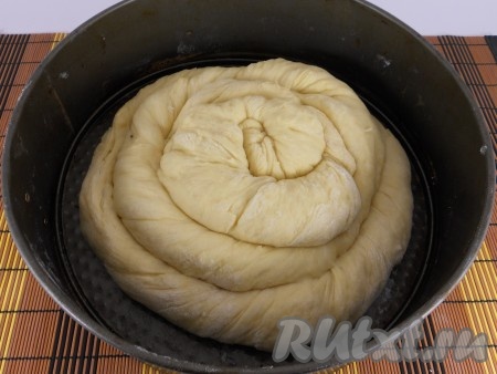 Разделить тесто на 3 части, скатать жгуты. Немного их перекрутить и сворачивать прямо в форме (форма диаметром 24-25 см), смазанной маслом, в виде витушки.
