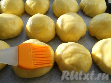 Желток размешать со сливками и этой смесью смазать булочки. Оставить их для расстойки в теплом месте на 30-40 минут.