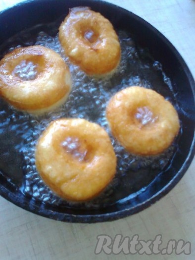 В сковороде с высокими бортиками или в сотейнике на сильном огне разогреть растительное масло, убавить огонь до среднего и обжарить пончики с двух сторон до золотистого цвета.