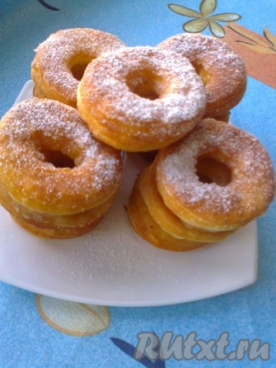 Готовые творожные пончики-колечки выложить на бумажные салфетки, чтобы удалить излишки масла. Перед подачей посыпать сахарной пудрой