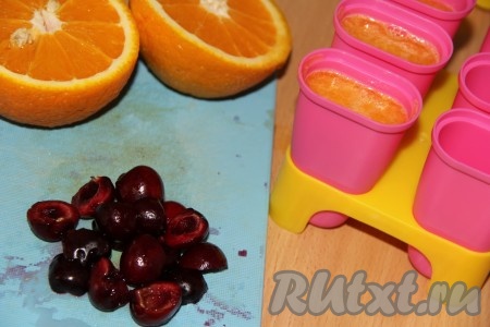 Черешню вымыть, удалить косточки. Разрезать черешню пополам. Я сделала два вида льда, один - просто апельсиновый, а другой - апельсиновый с кусочками черешни. Выложить кусочки черешни в формочки для льда. Залить в формочки свежевыжатый апельсиновый сок.