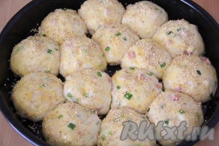 Поднявшиеся булочки смазать молоком, по желанию, посыпать сверху кунжутом.