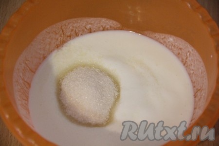 Кефир влить в глубокую миску, всыпать соду и перемешать. Кефир начнёт пузыриться, это говорит о том, что сода погасилась. Далее добавить сахар и хорошо перемешать.