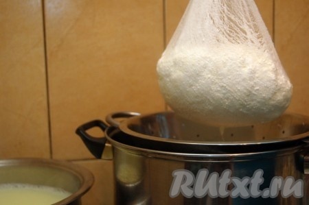 Периодически приподнимать марлевый мешочек с сыром, чтобы лучше стекала сыворотка.