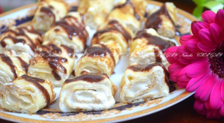 Уверена, вы по достоинству оцените эти блинные рулетики с творогом. Блинчики внешне напоминают роллы, на вкус они потрясающие и очень красиво смотрятся на большом блюде. В общем, отличный творожно-блинный десерт! 