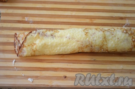 Сворачиваем блин в рулет. Так поступаем со всеми блинами и со всей начинкой.
