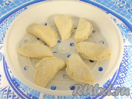 Слепить вареники обычным способом. Выложить их в форму для варки на пару.