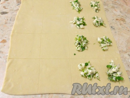 Отдохнувшее тесто раскатать тоненько в виде прямоугольника. Наметить ножом квадраты или прямоугольники (10х10 или 10х8). Я разрезала прямоугольный пласт на 16 частей. На половину из них выложить сыр с зеленью.
