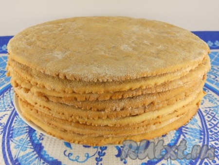 Достать готовый корж из духовки, дать остыть. Постепенно раскатать и испечь все 10 медовых коржей, дать им остыть.