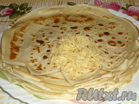 На каждый блин выложить по столовой ложке натёртого сыра.
