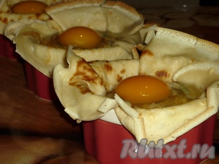 Поверх начинки аккуратно разбить яйцо. Отправить креманки на 16-18 минут в духовку, предварительно разогретую до 180 градусов. Обязательно следите, чтобы блинчики не пригорели (края блинов можно прикрыть фольгой).
