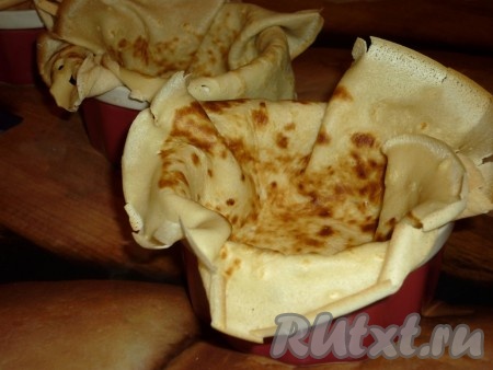 Смазать сливочным маслом жаропрочные креманки. Выложить в каждую креманку по блину.
