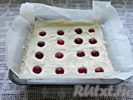 По желанию в запеканку можно добавить ягоды. Я решила использовать вишню. Свежую вишню вымыть, удалить из неё косточки. Замороженные ягоды, если на них мало льда, можно не размораживать. Разложить вишню поверх творожно-манного слоя, слегка вдавить, как на фото.