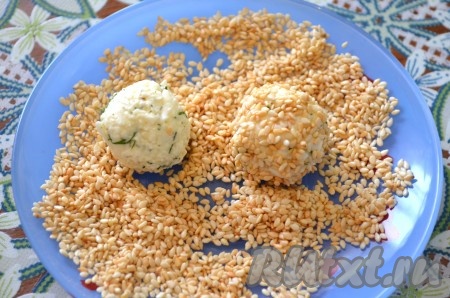 Непосредственно перед подачей обвалять сырные шарики со всех сторон в кунжуте.